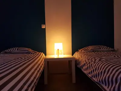a room with two beds with a lamp on a table at Casa Io - Goraz in Mindelo