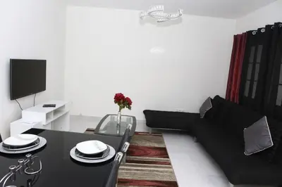 a living room with a black couch and a table at Apartamento Micael in Praia