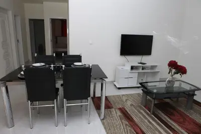 a dining room with a table and chairs and a television at Apartamento Micael in Praia