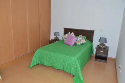 a bedroom with a green bed with pillows on it at Apartamento Ireny in Praia