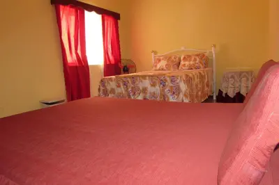 a bedroom with a bed and a window with red curtains at Rooming house in Espargos