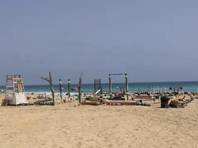 a beach with a bunch of chairs and a playground at Good value low cost apartment second beach line in Santa Maria