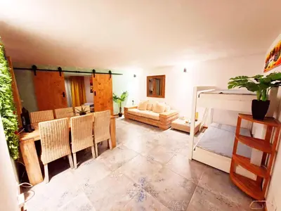 a living room with a bed and a table and chairs at Penthouse with rooftopbar, Fiber WiFi, next to the beach! in Santa Maria
