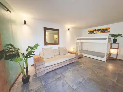 a living room with a couch and a bunk bed at Penthouse with rooftopbar, Fiber WiFi, next to the beach! in Santa Maria