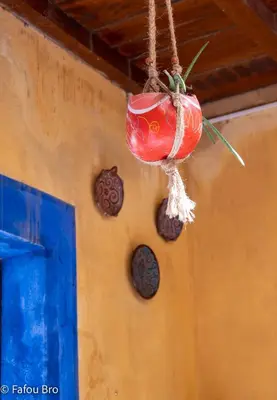 a red pot hanging from a wall with cookies at Sakaroule B&B in Santa Maria
