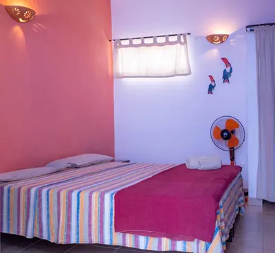 a bedroom with a bed with a striped blanket and a window at Sakaroule B&B in Santa Maria