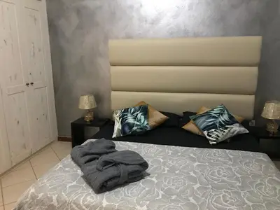 a bedroom with a bed with a blanket on it at Blue Eagle Guesthouse - Casa de hospedes in Santa Maria