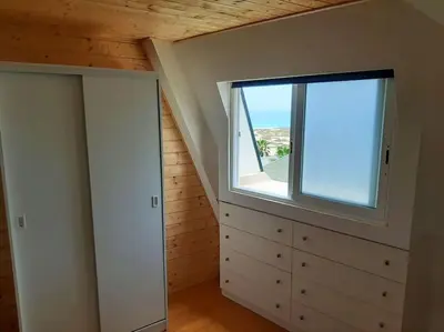 a bedroom with a window in a house at Beach penthouse with rooftopbar and Fiber WiFi, spectacular 180 degrees ocean view in Santa Maria