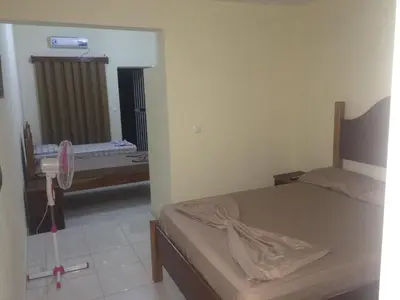 a bedroom with a bed and a sink and a mirror at Pensao Motel Sodade in São Filipe