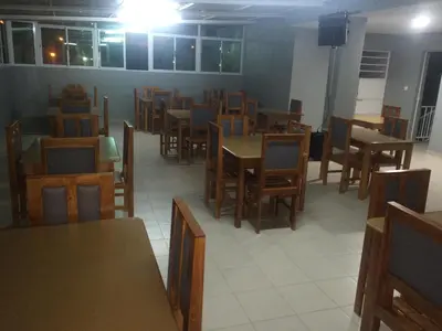 a dining room with wooden tables and chairs at Pensao Motel Sodade in São Filipe