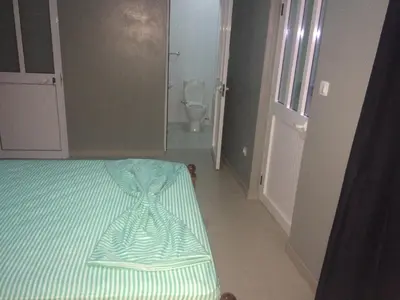 a bedroom with a bed with a green and white stripes at Pensao Motel Sodade in São Filipe