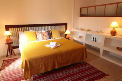 a bedroom with a large yellow bed with two lamps at Casa Colonial Koenig in São Filipe