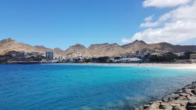 a beach with a group of people in the water at Apartamento Xandinha Amwilla Guesthouse in Mindelo
