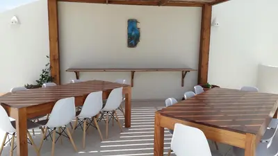 a conference room with wooden tables and white chairs at B&B Sereia Azul Boa Vista in Sal Rei