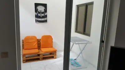an orange chair in a room with a table at ka-Bela in Sal Rei