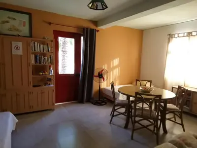 a living room with a table and chairs and a red door at Chambre indépendante in Porto Novo