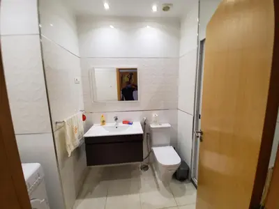 a white bathroom with a sink and a toilet at Apto Duarte T2 in Praia