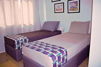a bedroom with two beds and a window at Kasa Imbondeiro in Mindelo