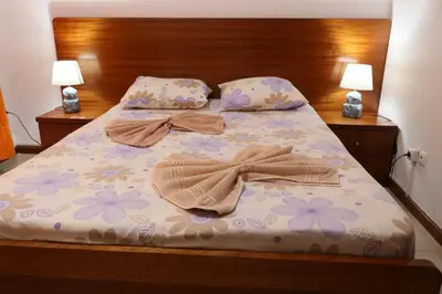a bed with two towels and two lamps on it at O Jardim do Vinho, AC in Praia