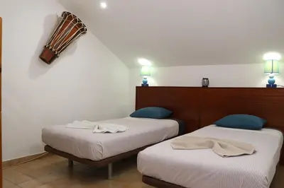 a room with two beds with towels on them at O Jardim do Vinho, AC in Praia