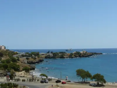 a view of a beach and the ocean with cars at O Jardim do Vinho, AC in Praia