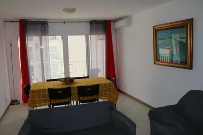 a living room with a table and chairs and a window at Complexo Multiuso Copacabana in Mindelo