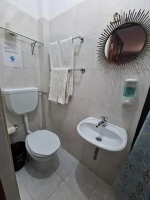 a bathroom with a toilet and a sink and a mirror at Residencial Raiar in Mindelo