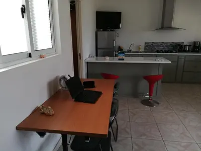 a kitchen with a wooden table with a laptop on it at Casa Yô in Mindelo