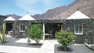 a stone house with trees in front of a mountain at Casa helena in Portela