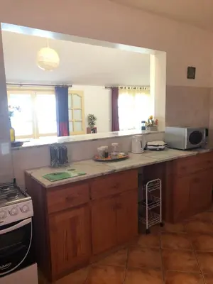 a kitchen with wooden cabinets and a counter top at XXL Apt w/ Surprising Gorgeous Ocean View in Praia