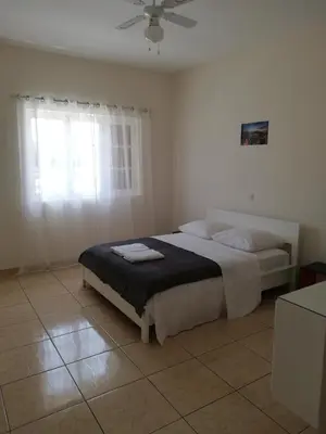 a bedroom with a bed and a window at Résidence Yô in Mindelo