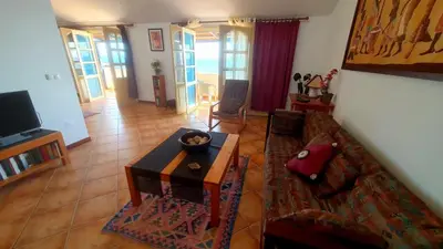 a living room with a couch and a table at Couple Getaway with Panoramic Ocean View in Praia