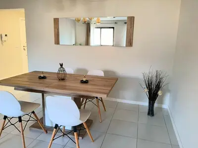 a dining room table with white chairs and a mirror at Apartment with pool in Mindelo in Mindelo