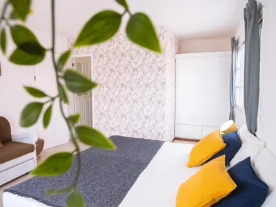 a bedroom with a bed with yellow pillows and a plant at Casa Blu Guesthouse - Casa de Hospedes in Santa Maria