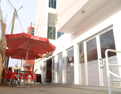 a red umbrella and tables and chairs in front of a building at Domingas in Praia