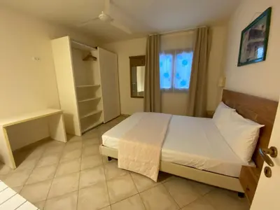 a bedroom with a white bed and a window at Zen House Tropical in Santa Maria