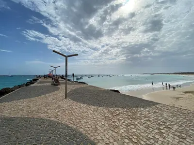 a beach with a group of people walking on the beach at Zen House Tropical in Santa Maria