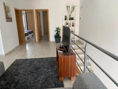 a living room with a tv on a stand in a staircase at Paradise Cape Verde in Santa Maria