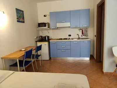 a small kitchen with blue cabinets and a table at Sal&Love apt in Porto Antigo in Santa Maria