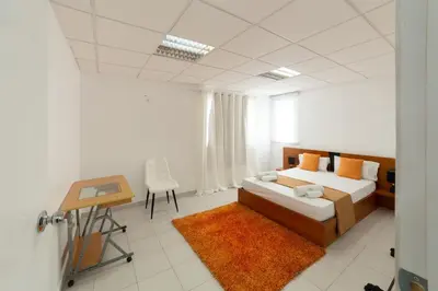 a bedroom with a bed and a table and a desk at A Casa da Mizi in Praia