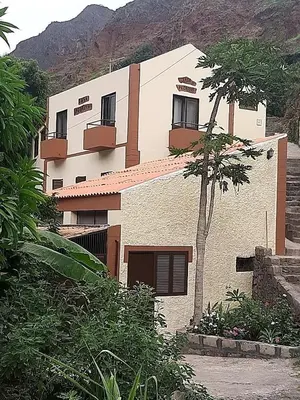 a white building with a tree in front of it at Casa Pedrina in Ribeira Grande