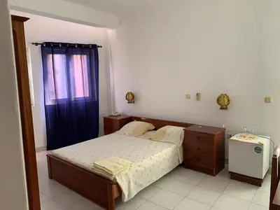 a small bedroom with a bed and a window at Residencial Pôr do Sol in Porto Novo