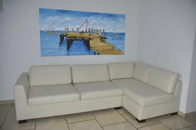 a living room with a couch and a painting on the wall at Apartamento Moradias Djadsal C01 próximo à Praia de Santa Maria in Espargos