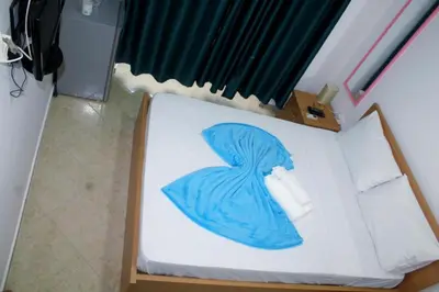 a bed with a blue blanket on top of it at Plateau Bedroom & Chambre - Praia Center 1 in Praia