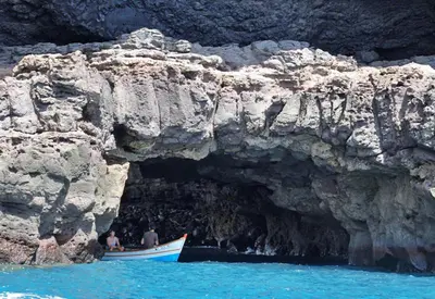 two people in a boat in front of a cave at Hotel Avenida in Assomada