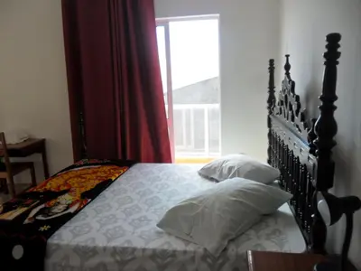 a bedroom with a large bed with a window at Casa Celeste in Ponta do Sol
