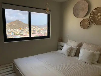 a bedroom with a large white bed with a window at Harmony apartment in Mindelo São Vicente in Mindelo