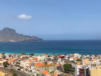 a city with houses and the ocean in the background at Harmony apartment in Mindelo São Vicente in Mindelo