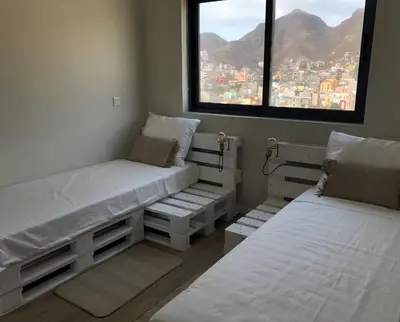 two beds in a room with a view of a city at Harmony apartment in Mindelo São Vicente in Mindelo