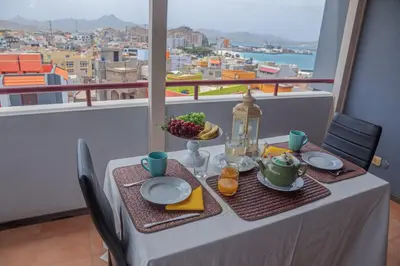a table with food and a view of a city at Criola Vistamar in Mindelo